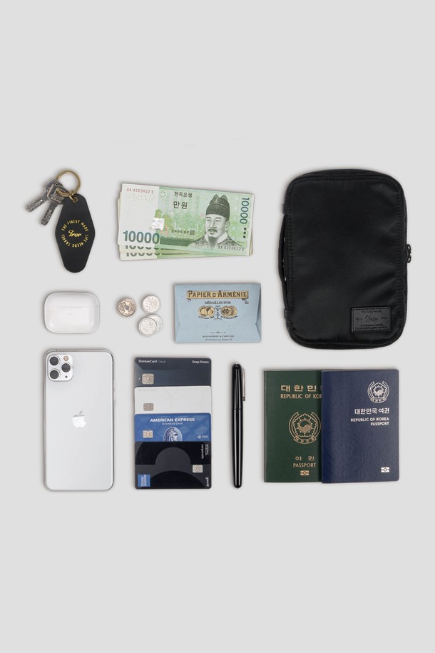 블랙 색상의 Staple Passport Pouch는 여행 및 일상에서 활용하기 좋은 스몰 사이즈의 여권지갑입니다. 나일론 소재로 제작되어 생활 방수가 가능하며, 여권 3개와 카드 4장을 수납할 수 있는 넉넉한 공간을 제공합니다. 탈부착 가능한 어깨 스트랩과 후면 카드 슬롯, 메쉬 포켓, 펜 포켓 등의 디테일이 더해진 사각 형태의 지퍼형 여권지갑입니다.
