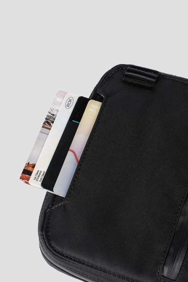 블랙 색상의 Staple Passport Pouch는 여행 및 일상에서 활용하기 좋은 스몰 사이즈의 여권지갑입니다. 나일론 소재로 제작되어 생활 방수가 가능하며, 여권 3개와 카드 4장을 수납할 수 있는 넉넉한 공간을 제공합니다. 탈부착 가능한 어깨 스트랩과 후면 카드 슬롯, 메쉬 포켓, 펜 포켓 등의 디테일이 더해진 사각 형태의 지퍼형 여권지갑입니다.
