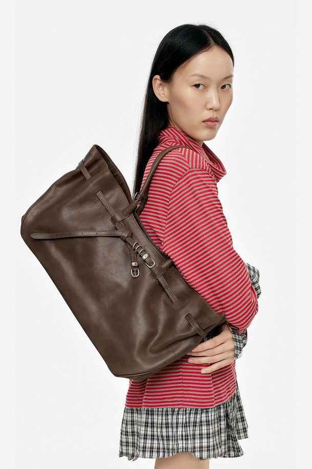 그랜드마 유즈드 백 라지_워시드 브라운 풀업은 은은한 광택과 자연스러운 주름이 특징인 풀업 레더 소재의 소가죽 토트백입니다. 14인치 노트북 수납이 가능한 넉넉한 라지 사이즈로, 내부 포켓과 링형 잠금 방식으로 실용성을 더했습니다. 사각형 디자인과 브라운 컬러, 버클 장식이 클래식하면서도 시크한 분위기를 연출하며, 빈티지 스타일을 즐기는 여성분들께 적합합니다. 면 안감과 더스트백이 포함되어 있으며, 오피스룩, 비즈니스 캐주얼, 출근룩 등 다양한 TPO에 잘 어울립니다.
