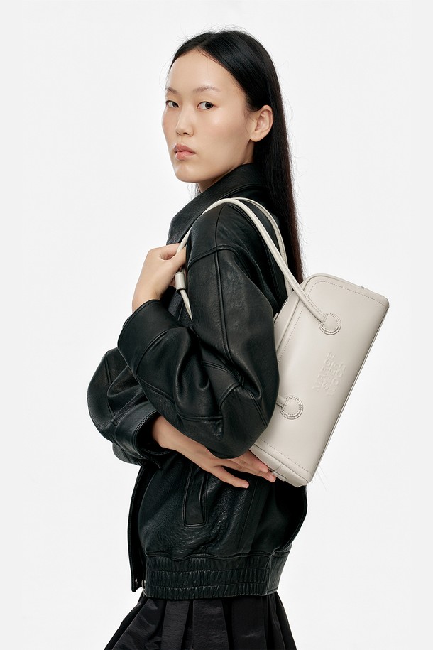 소프트 보스턴 EW_라이트 그레이 플레인 여성 가방은 부드러운 소가죽 소재의 미디엄 사이즈 보스턴백입니다. 라이트 그레이 컬러의 무지 디자인에 로고 엠보싱 장식이 돋보이며, 내부 지퍼 포켓과 슬립 포켓으로 실용성을 더했습니다. 가방은 사각 모양이며 지퍼로 잠금 가능하며, 고정형 손잡이와 로고 프린트 안감이 특징입니다. 출근룩과 모임룩에 클래식, 미니멀, 시크한 스타일을 연출하기 좋습니다. 자연스러운 가죽 무늬와 주름이 있으며, 더스트백이 포함되어 있습니다.
