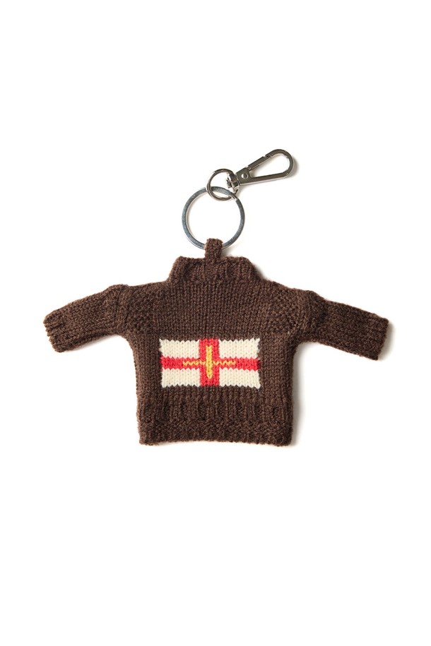 건지 더블크로스 스웨터 키링 - 브라운은 건지 섬의 더블크로스 국기 모티프를 담아낸 클래식 & 미니멀 스타일의 키링입니다. 브라운 컬러를 기반으로 아크릴 소재, 밀도 높은 짜임과 단단한 조직감, 여러 겹 꼬임 원사를 사용하여 보온성을 높였습니다. T자 형태, 파도, 빗줄 무늬에서 영감을 얻은 디자인은 두꺼운 두께감으로 독특한 매력을 선사합니다. 핑거홀 디테일이 더해져 실용성을 갖춘 데일리 아이템입니다.
