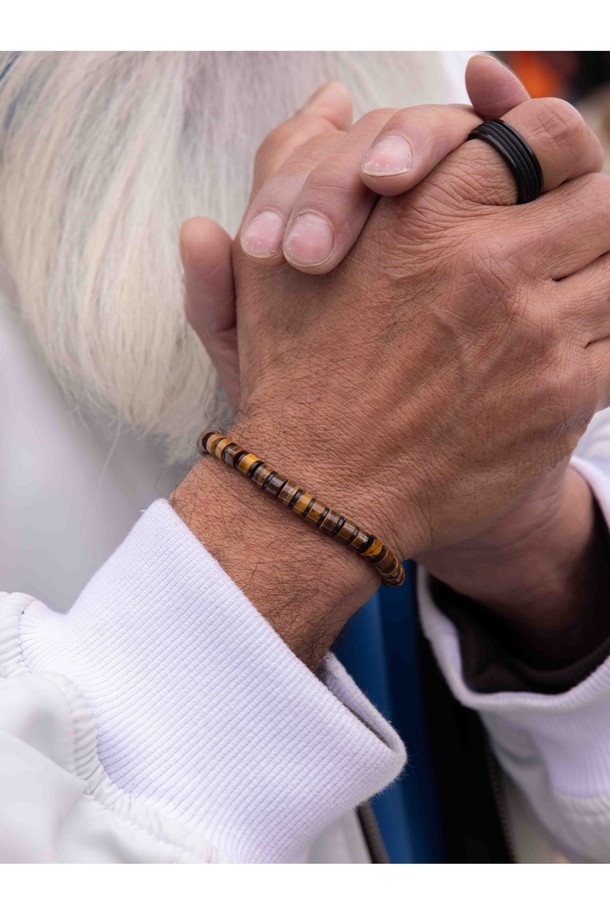 브론타이드 6 팔찌는 타이거아이와 블랙 컬러의 조화가 돋보이는 공용 쥬얼리입니다. 6mm 두께의 로프, 스테인리스 스틸, 천연석 소재로 제작되었으며, 번개 모티프와 브랜드 각인, 수작업 매듭 디자인이 특징입니다. 방수, 내구성, 내염성, 내부식성 기능은 물론 레이어드 연출과 착용감, 위생적인 관리까지 고려하여 일상과 수상 스포츠 활동 모두에 적합합니다.
