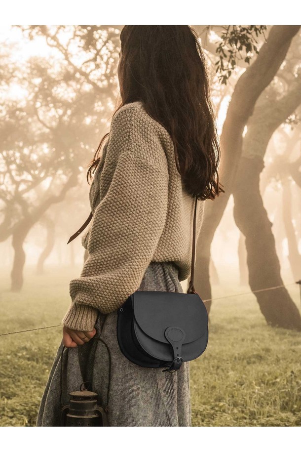 다이앤 새들백 M - 누아르 블랙은 출근룩, 비즈니스 캐주얼, 모임룩에 모두 잘 어울리는 남성용 새들백입니다. 클래식, 미니멀, 시크 스타일을 추구하는 남성에게 적합하며, 부드러운 소가죽 소재로 제작되어 고급스러운 질감을 선사합니다. 가방은 무지 패턴의 블랙 컬러에 버클 장식으로 포인트를 더했으며, 반원 형태의 디자인과 마그네틱형 잠금 방식으로 실용성을 높였습니다. 내부에는 분리 수납이 가능한 구조와 YKK 지퍼를 적용하여 수납력을 강화했으며, 식물성 태닝 가죽, 유기농 면 내부, 황동 하드웨어를 사용하여 섬세하게 제작되었습니다.
