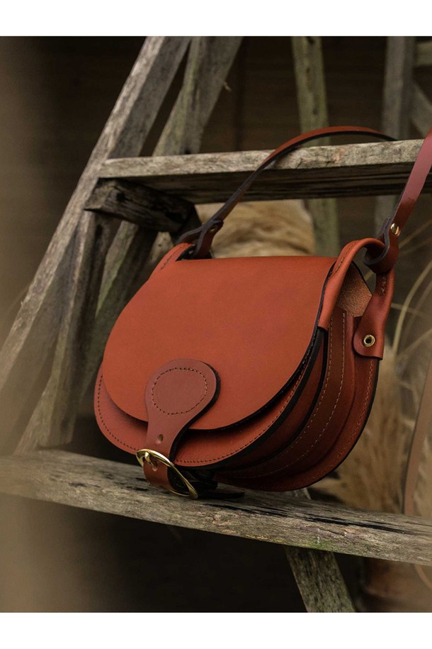 다이앤 새들백 L - 러스트는 클래식, 미니멀, 시크 스타일을 추구하는 여성 고객을 위한 라지 사이즈의 소가죽 새들백입니다. 러스트 컬러의 무지 디자인으로, 데이트룩, 쇼핑룩, 모임룩 등 다양한 TPO에 잘 어울립니다. 식물성 태닝 가죽과 유기농 면 내부, 황동 하드웨어, YKK 지퍼, 마그네틱형 잠금 방식으로 고급스러움을 더했습니다. 반원 모양의 가방은 사이즈 조절 및 손잡이 기능을 갖추었으며, 내부 분리 가능한 면 지퍼 포켓, 전면 및 후면 포켓, 7개의 지퍼 포켓, 2개의 접이식 포켓, 4개의 패치 포켓으로 수납력을 높였습니다. 수작업으로 제작된 모듈형 내부 구성은 실용성을 더합니다.
