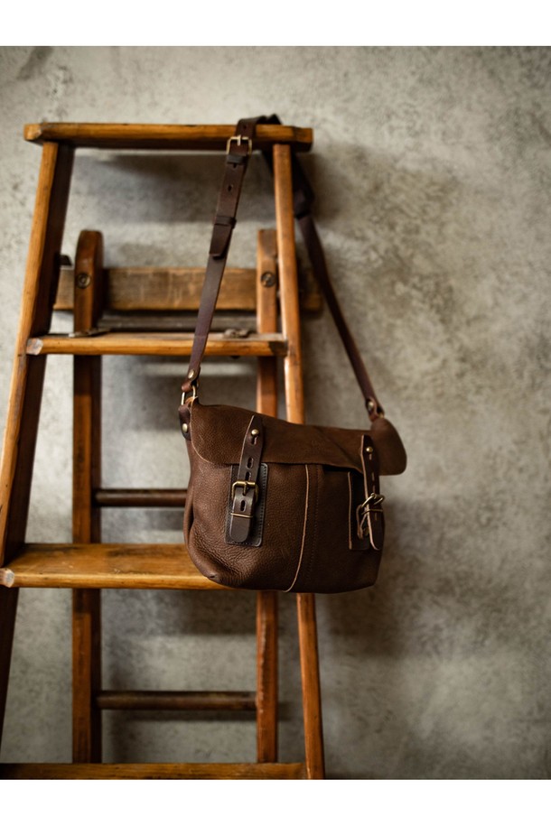 루이스 사첼백 - 쿠바 리브레는 베지터블 태닝 풀그레인 소가죽 소재의 미디엄 사이즈 여성용 사첼백입니다. "Cuba Libre"를 포함한 6가지 다채로운 컬러로 출시되었으며, 버클과 리벳 장식, YKK 지퍼, 황동 하드웨어로 고급스러움을 더했습니다. 7개의 지퍼 포켓, 2개의 폴딩 포켓, 4개의 패치 포켓을 갖춘 다중 수납공간과 모듈러 시스템 호환 기능을 통해 실용성을 높였으며, 버클형 및 버튼형 잠금 방식으로 내용물을 안전하게 보호합니다.
