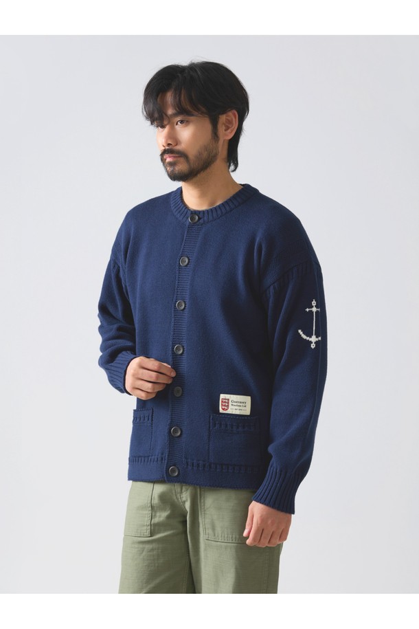 네이비 컬러의 헤비코튼 피셔맨 헤리티지 가디건입니다. 가을과 겨울, 일상 속에서 클래식하고 베이직한 스타일을 연출하기 좋습니다. 두꺼운 두께감의 면 소재로 제작되어 보온성을 높였으며, 단단한 촉감이 특징입니다. T자 형태의 헤리티지 패턴과 파도와 빗줄기를 형상화한 케이블 및 다이아몬드 무늬 짜임, 왼쪽 소매의 앵커 포인트가 돋보입니다. 핑거홀과 밑단 절개 디테일, 라운드넥, 레귤러핏, 긴소매, 버튼 여밈 방식으로 디자인되었습니다.
