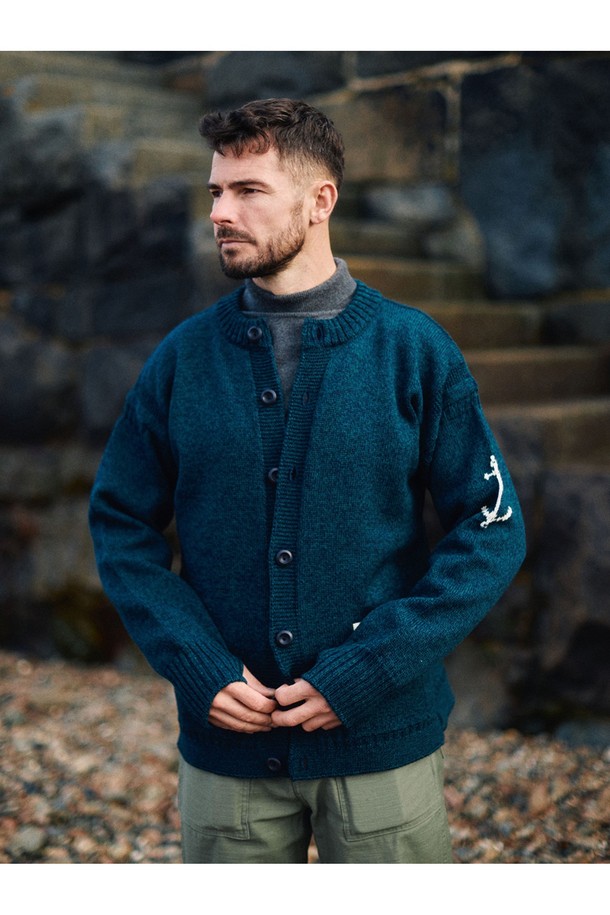 피셔맨 홀가먼트 가디건 - 블랙와치는 부드러운 울 소재로 제작되어 가을과 겨울에 따뜻하게 착용하기 좋은 두꺼운 두께감의 긴소매 가디건입니다. 클래식하고 베이직한 디자인으로 일상, 출근룩, 모임룩 등 다양한 상황에 활용할 수 있습니다. 레귤러핏으로 편안하게 착용 가능하며, 라운드넥 디자인으로 다양한 이너와 자연스럽게 매치됩니다. 특히, 앵커(닻) 자수 디테일이 포인트로 더해져 고급스러운 분위기를 연출합니다. 블랙와치 컬러가 세련된 스타일을 완성합니다.
