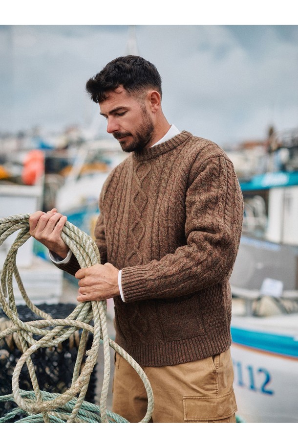 셔틀랜드울 아란 포켓 스웨터 - 모스 브라운은 클래식과 베이직 스타일을 추구하는 남성을 위한 겨울, 가을용 상의입니다. 두꺼운 두께감과 뻣뻣한 촉감, 보온 및 방풍 기능을 갖춘 이 스웨터는 일상과 출근룩, 모임룩에 적합합니다. 17세기 전통 편직 기법을 보존하여 제작되었으며, 전통적인 아란 니트 패턴과 포켓 디테일이 특징입니다. 링킹 기법으로 마감되었고, 아시아 체형에 맞는 사이즈로 제작되어 편안한 착용감을 선사합니다. 라운드넥, 긴소매, 레귤러핏의 레귤러 기장으로 디자인되었습니다.
