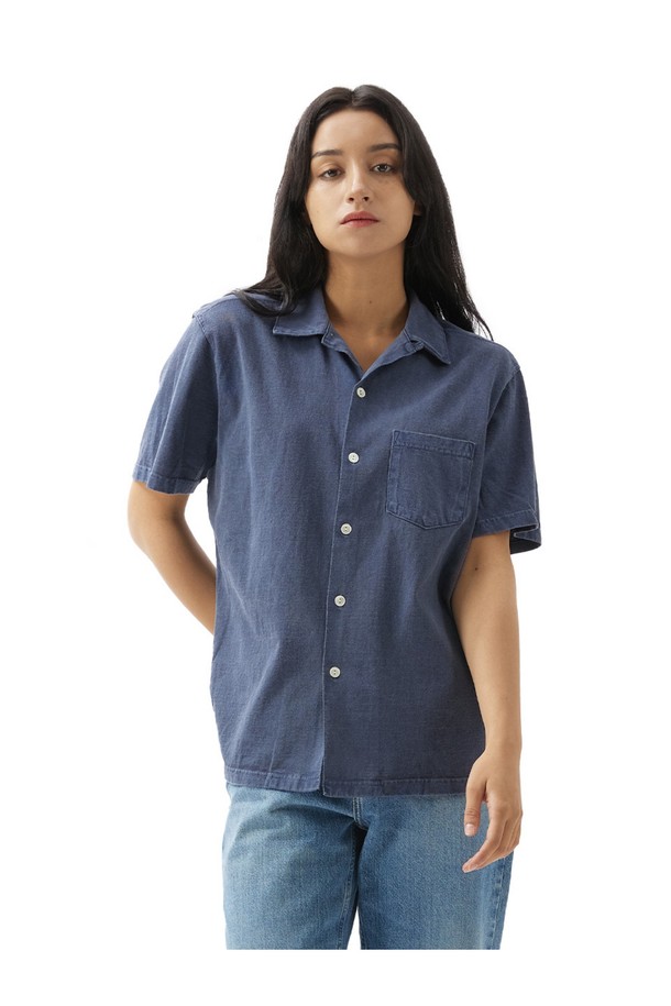 피그먼트 네이비 컬러의 오픈 카라 반팔 셔츠입니다. 부드러운 면 소재에 스탠다드 핏으로 제작되어 편안한 착용감을 선사하며, 일상복으로 활용하기 좋습니다. 2바늘 커버스티치 봉제와 목/어깨 보강 테이프로 내구성을 높였으며, 세탁과 착용을 통해 자연스러운 에이징 효과를 즐길 수 있습니다.
