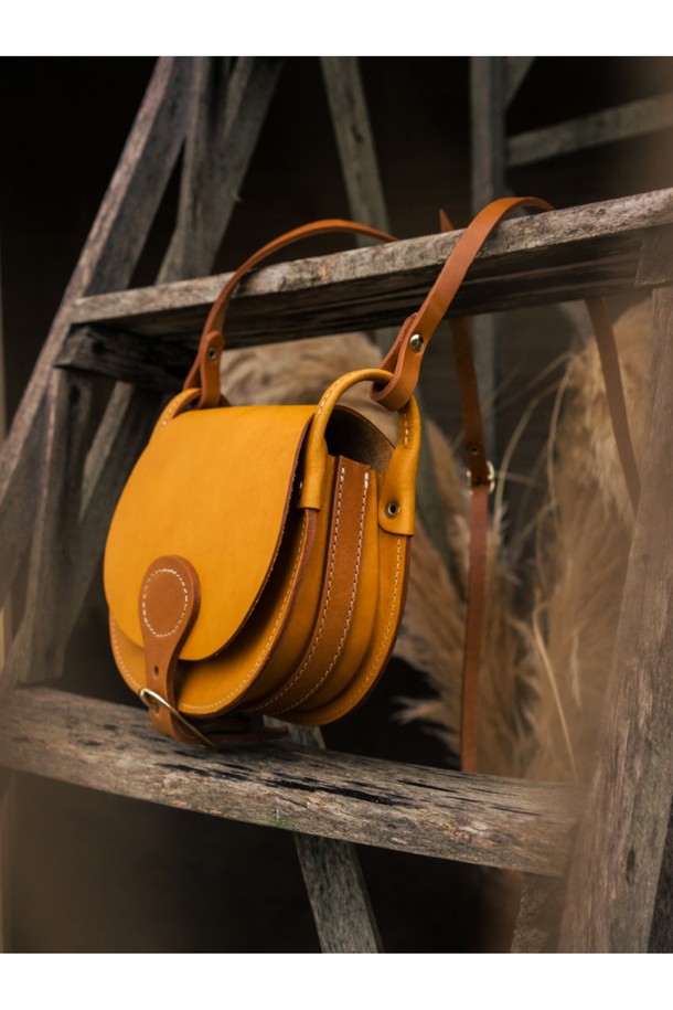 다이앤 새들백 M - 미엘은 클래식한 무드를 자아내는 남성용 새들백입니다. 블랙과 러스트 컬러로 출시되었으며, 식물성 태닝 처리된 풀그레인 소가죽 소재로 제작되어 자연스러운 가죽 질감을 느낄 수 있습니다. 내부에는 유기농 면을 사용하여 편안함을 더했으며, 황동 하드웨어와 YKK 지퍼, 수작업 마감으로 디테일을 높였습니다. 반원 형태의 디자인에 버클과 자수 장식이 포인트로, 출근룩, 비즈니스 캐주얼, 모임룩 등 다양한 TPO에 시크하고 미니멀한 스타일을 더해줍니다.
