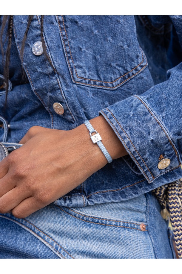 **빌리 팔찌 - 아크틱블루X실버**는 여성 고객을 위한 팔찌로, 미니멀, 리조트, 클래식 스타일을 추구하는 분들께 추천합니다. 아크틱블루 컬러의 고강도 선박용 로프와 실버 컬러의 스테인리스 스틸 소재가 조화롭게 어우러져 내구성과 내식성이 뛰어납니다. 자물쇠 모양의 클래스프와 레이저 각인 디테일이 돋보이며, 손바느질 마감으로 섬세함을 더했습니다. 방수 기능과 바닷물, 염분에 강해 휴가룩, 리조트룩, 여행룩에 포인트 아이템으로 활용하기 좋습니다. 레이어드하여 더욱 다채로운 스타일을 연출할 수 있습니다.
