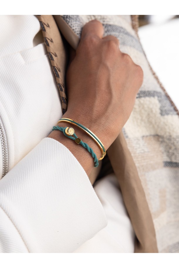여성스러운 감각을 더해줄 마야 루 팔찌 - 파티나그린X골드입니다. 파티나그린과 골드 컬러 조합이 세련된 조화를 이루며, 스테인리스 스틸과 마린 로프 소재로 제작되어 내구성과 방수 기능을 갖췄습니다. 로프 패턴 디자인과 수작업 스티치 디테일이 돋보이며, 커프 스타일로 편안하게 착용할 수 있습니다. 클래식, 미니멀, 캐주얼 등 어떤 스타일에도 잘 어울리며, 휴가룩, 여행룩에 포인트 아이템으로 활용하기 좋습니다. 레이어드하여 개성 있는 스타일을 연출해보세요.
