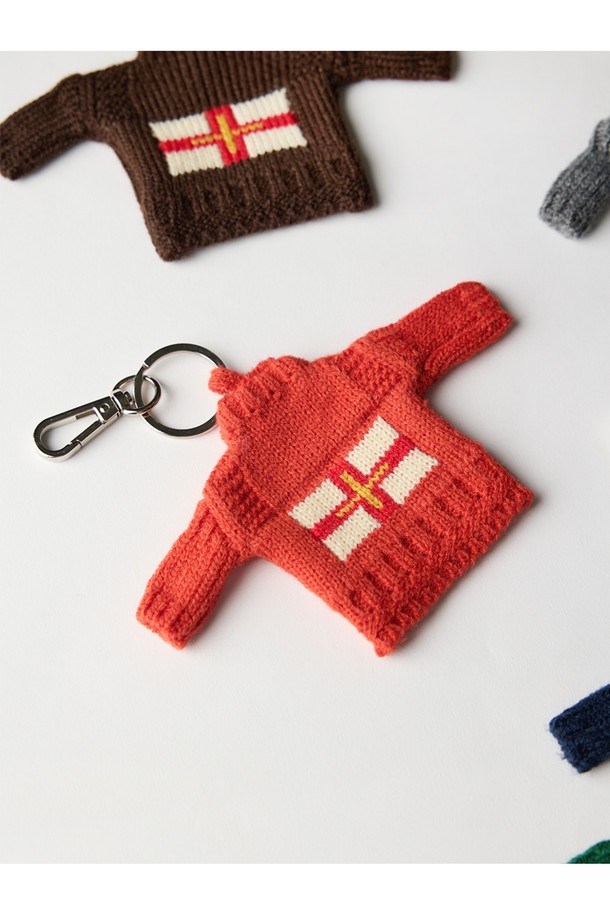 건지 더블크로스 스웨터 키링 - 브라운은 건지 섬의 더블크로스 국기 모티프를 담아낸 클래식 & 미니멀 스타일의 키링입니다. 브라운 컬러를 기반으로 아크릴 소재, 밀도 높은 짜임과 단단한 조직감, 여러 겹 꼬임 원사를 사용하여 보온성을 높였습니다. T자 형태, 파도, 빗줄 무늬에서 영감을 얻은 디자인은 두꺼운 두께감으로 독특한 매력을 선사합니다. 핑거홀 디테일이 더해져 실용성을 갖춘 데일리 아이템입니다.
