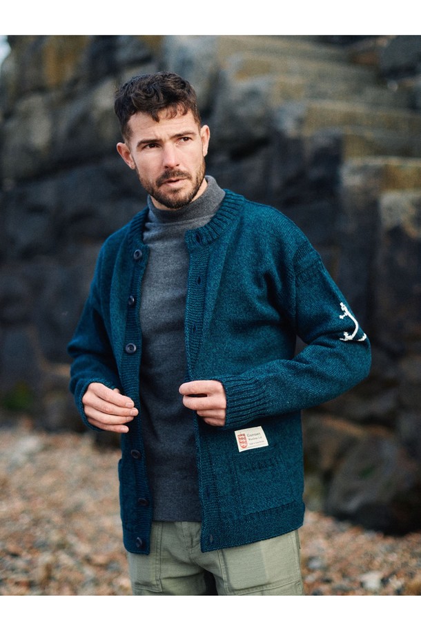 피셔맨 홀가먼트 가디건 - 블랙와치는 부드러운 울 소재로 제작되어 가을과 겨울에 따뜻하게 착용하기 좋은 두꺼운 두께감의 긴소매 가디건입니다. 클래식하고 베이직한 디자인으로 일상, 출근룩, 모임룩 등 다양한 상황에 활용할 수 있습니다. 레귤러핏으로 편안하게 착용 가능하며, 라운드넥 디자인으로 다양한 이너와 자연스럽게 매치됩니다. 특히, 앵커(닻) 자수 디테일이 포인트로 더해져 고급스러운 분위기를 연출합니다. 블랙와치 컬러가 세련된 스타일을 완성합니다.
