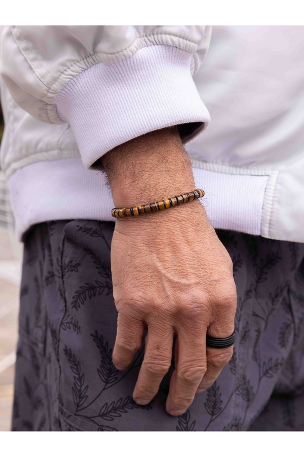 브론타이드 6 팔찌는 타이거아이와 블랙 컬러의 조화가 돋보이는 공용 쥬얼리입니다. 6mm 두께의 로프, 스테인리스 스틸, 천연석 소재로 제작되었으며, 번개 모티프와 브랜드 각인, 수작업 매듭 디자인이 특징입니다. 방수, 내구성, 내염성, 내부식성 기능은 물론 레이어드 연출과 착용감, 위생적인 관리까지 고려하여 일상과 수상 스포츠 활동 모두에 적합합니다.
