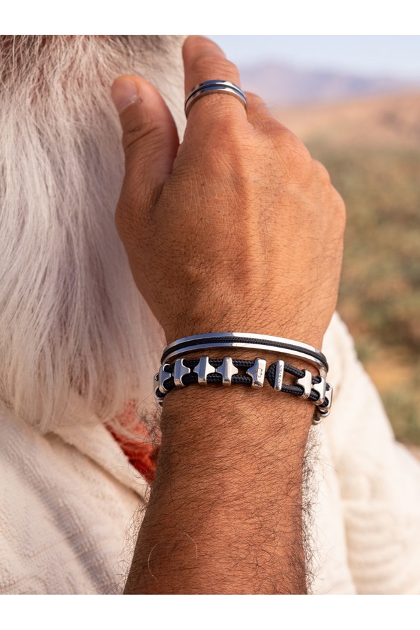 네이비 로프와 실버 스퀘어 디자인의 나바크 4 반지입니다. 네덜란드 선원 생존 상징을 모티브로, 돼지와 닭 모티브, 브랜드 레터링 각인이 특징이며, 19호와 21호 사이즈로 제공됩니다. 스테인리스스틸과 로프 소재로 제작되어 해수, 땀, 변색에 강하며, 해양/항해 컨셉의 방수 기능을 갖춘 수제작 반지로, 우드 케이스에 담겨 선물용으로도 좋습니다.
