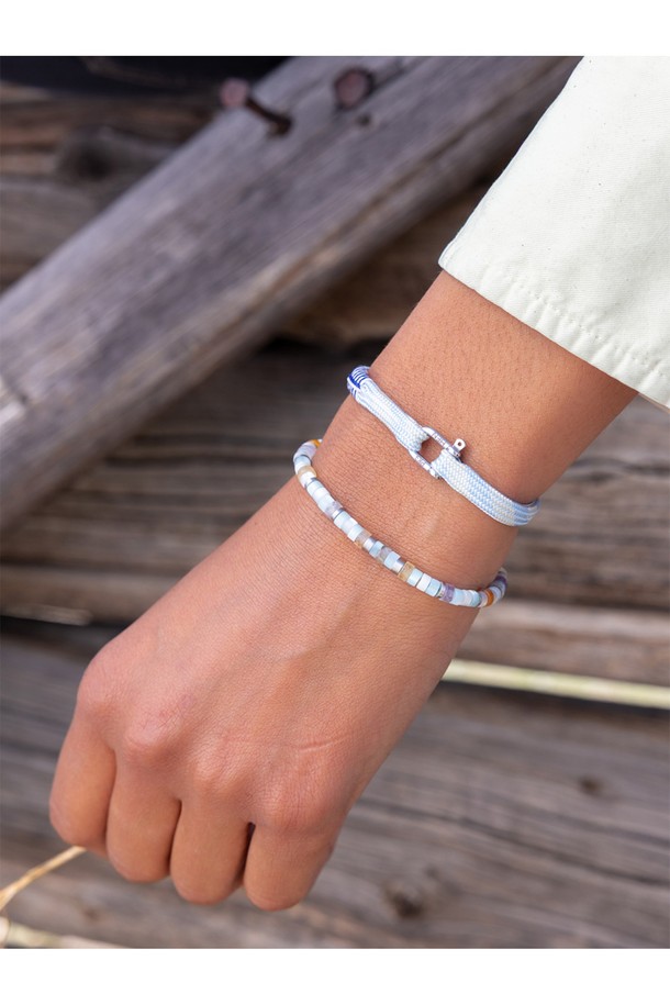 (여성) 프랭키 팔찌 - 아크틱블루, 크림, 실버는 미니멀, 클래식, 리조트 스타일을 즐기는 여성들을 위한 팔찌입니다. 아크틱블루, 크림, 실버 세 가지 색상의 조화가 돋보이며, 일상 및 파티룩에 모두 잘 어울립니다. 스테인리스 스틸과 로프 소재로 제작되어 내식성과 내구성이 뛰어나며, 100% 수작업으로 섬세하게 완성되었습니다. 선박용 플랫 로프를 사용하여 해수 및 염분에 강하며, 2개 이상 레이어드하여 착용하면 더욱 멋스러운 연출이 가능합니다. 레이저 각인과 매듭 디테일이 더해져 디자인의 완성도를 높였습니다.
