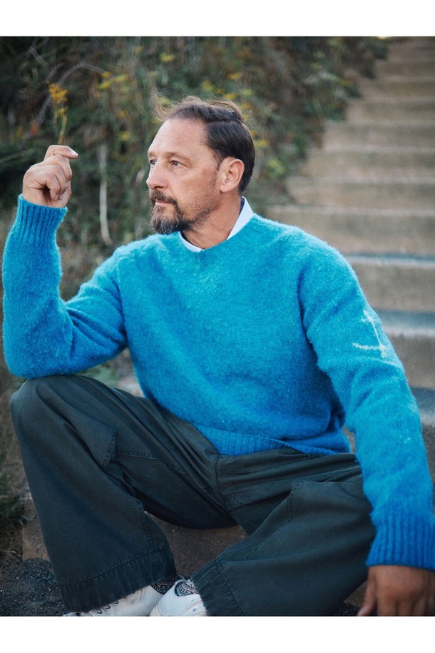 셔틀랜드울 쉐기독 홀가먼트 스웨터 - 피카딜리는 포근함과 클래식한 멋을 동시에 선사하는 남녀 공용 스웨터입니다. 셔틀랜드울 소재 특유의 부드러운 촉감과 두꺼운 두께감으로 가을, 겨울철 따뜻하게 착용 가능합니다. 브러싱 처리된 울 표면과 공기층 형성으로 보온성을 극대화했으며, 빈티지한 느낌을 더해주는 에이징 기법이 돋보입니다. 3차원 입체 실루엣과 왼쪽 소매 앵커 포인트 디테일, 전통적인 피셔맨 스웨터 디자인으로 미니멀, 클래식, 캐주얼 등 다양한 스타일을 연출할 수 있습니다. 다양한 색상 중 피카딜리 컬러는 어떤 룩에도 포인트를 더해줍니다.
