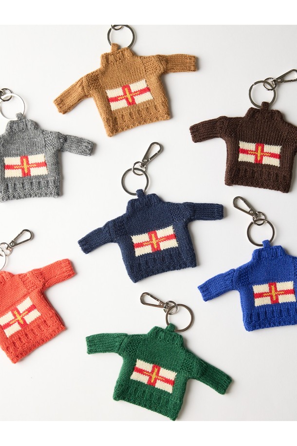 건지 더블크로스 스웨터 키링 - 그레이는 17세기부터 이어져 온 전통적인 건지 스웨터 디자인을 축소하여 제작된 키링입니다. 묵직한 두께감과 단단한 아크릴 소재로 견고함을 더했으며, 밀도 높은 짜임으로 클래식하고 헤리티지한 무드를 연출합니다. 더블크로스, T자형, 파도, 빗줄 등 섬세한 패턴과 세인트 조지 십자가, 금색 십자가 디자인 장식이 돋보입니다. 데이트룩, 모임룩, 또는 미니멀, 캐주얼 스타일 모두에 잘 어울리는 장식용 키홀더입니다.
