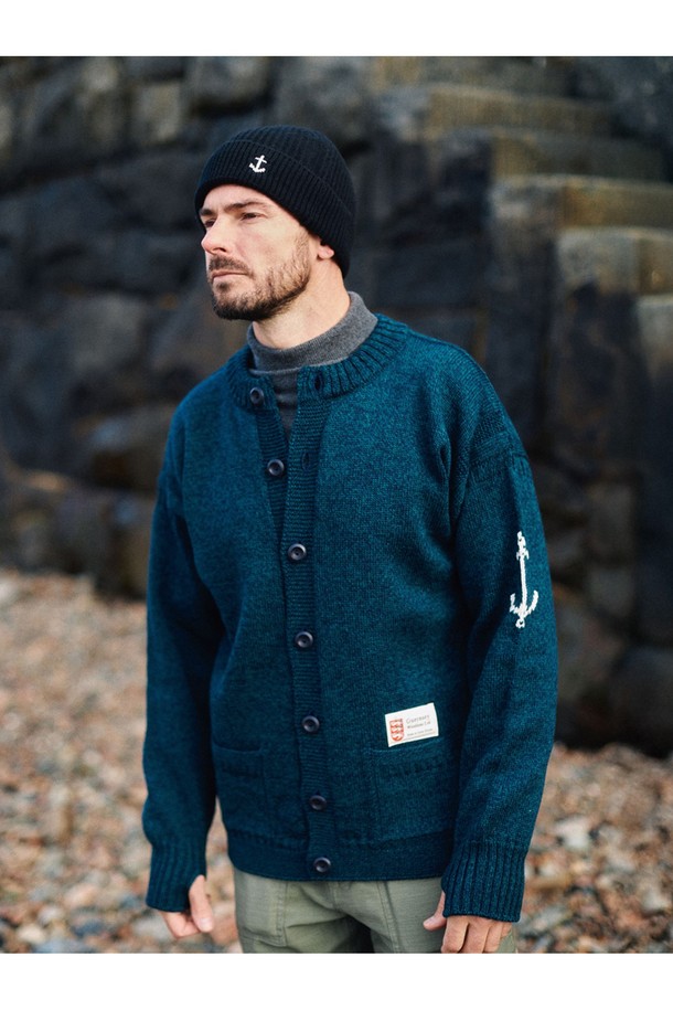 피셔맨 홀가먼트 가디건 - 블랙와치는 부드러운 울 소재로 제작되어 가을과 겨울에 따뜻하게 착용하기 좋은 두꺼운 두께감의 긴소매 가디건입니다. 클래식하고 베이직한 디자인으로 일상, 출근룩, 모임룩 등 다양한 상황에 활용할 수 있습니다. 레귤러핏으로 편안하게 착용 가능하며, 라운드넥 디자인으로 다양한 이너와 자연스럽게 매치됩니다. 특히, 앵커(닻) 자수 디테일이 포인트로 더해져 고급스러운 분위기를 연출합니다. 블랙와치 컬러가 세련된 스타일을 완성합니다.
