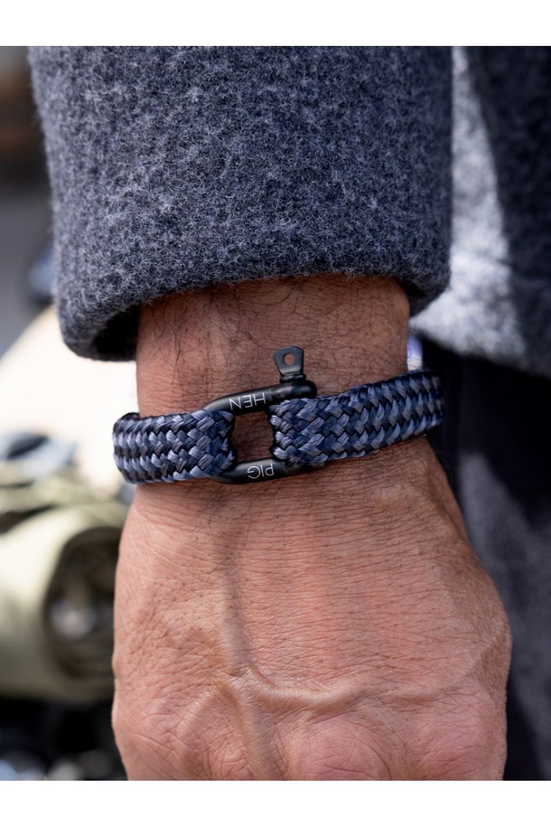 고저스 조지 팔찌는 네이비, 슬레이트그레이, 블랙 3가지 색상의 마린로프와 스테인리스 스틸 소재로 제작된 공용 팔찌입니다. 일상, 여행룩, 휴가룩 등 다양한 TPO에 활용 가능하며, 캐주얼, 미니멀, 클래식 스타일을 아우르는 디자인입니다. 팔찌에는 레이저 각인과 돼지, 닭 모티프 장식이 돋보이며, 수작업 스티치 및 매듭 마감으로 견고함을 더했습니다. 방수, 내구성, 내식성이 뛰어나며, 해수 저항성과 절단 저항성을 갖춰 오랫동안 변함없이 착용할 수 있습니다. 착용할수록 편안해지는 것이 특징이며, 녹슬지 않는 하드웨어와 우든 케이스 포장으로 고급스러움을 더했습니다.
