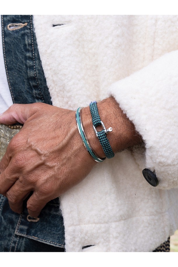 "나바크 6" 팔찌는 파티나그린 색상과 실버 색상의 조화가 돋보이는 공용 팔찌입니다. 316L 의료용 스테인리스 스틸과 1.8mm 고강도 마린로프를 사용하여 제작되어 일상생활은 물론 마린 스포츠 활동에도 적합합니다. 미니멀하고 캐주얼한 스타일로, 여행룩에 포인트 아이템으로 활용하기 좋습니다. 레이저 각인으로 디자인 포인트를 더했으며, 방수, 내식성, 내구성이 뛰어나 변색 없이 오래도록 착용할 수 있습니다. 100% 수작업으로 꼼꼼하게 제작되었으며, 비노출 이음새 마감과 소금물 저항성을 갖춰 섬세함과 실용성을 모두 놓치지 않았습니다.
