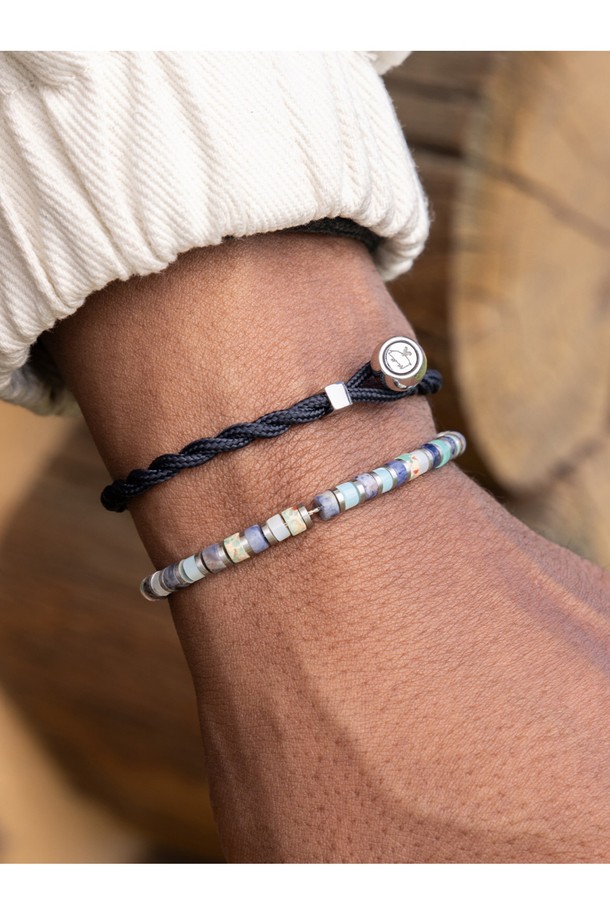 브론타이드 4 팔찌 - '후지'와 실버 컬러의 조화가 돋보이는 브론타이드 4 팔찌입니다. 공용으로 착용 가능하며, 스테인리스 스틸과 마린 로프 소재를 사용하여 내구성과 방수 기능을 갖췄습니다. 4mm 두께의 브레이드 패턴, 번개 디자인 모티브, 수작업 매듭 디테일이 특징이며, 슬라이더로 사이즈 조절이 가능합니다. 미니멀하고 캐주얼한 스타일로 일상, 해양스포츠, 휴가, 여행 등 다양한 TPO에 매치하기 좋습니다. 다른 팔찌와 레이어드하여 개성 있는 스타일을 연출할 수도 있습니다.
