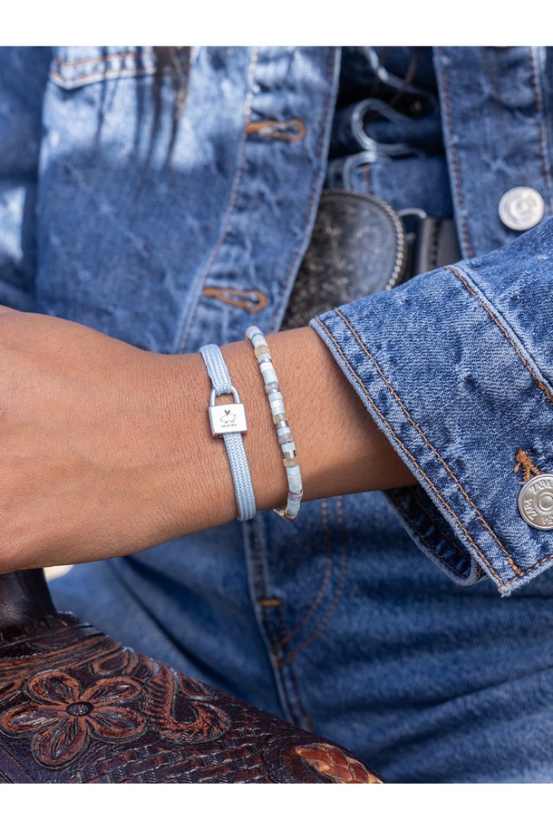 **빌리 팔찌 - 아크틱블루X실버**는 여성 고객을 위한 팔찌로, 미니멀, 리조트, 클래식 스타일을 추구하는 분들께 추천합니다. 아크틱블루 컬러의 고강도 선박용 로프와 실버 컬러의 스테인리스 스틸 소재가 조화롭게 어우러져 내구성과 내식성이 뛰어납니다. 자물쇠 모양의 클래스프와 레이저 각인 디테일이 돋보이며, 손바느질 마감으로 섬세함을 더했습니다. 방수 기능과 바닷물, 염분에 강해 휴가룩, 리조트룩, 여행룩에 포인트 아이템으로 활용하기 좋습니다. 레이어드하여 더욱 다채로운 스타일을 연출할 수 있습니다.
