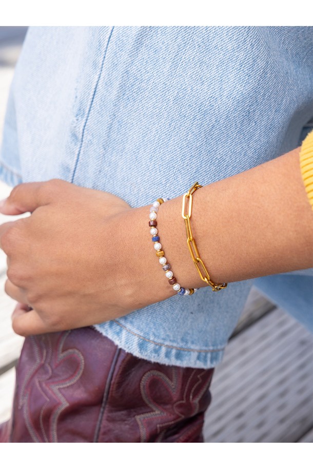 여성 브론타이드 4 팔찌 - 페루자X골드는 페루자와 골드 컬러 조합의 로프 소재 팔찌입니다. 돼지, 닭 패턴이 돋보이며, 캐주얼, 미니멀, 리조트 스타일로 여행룩, 휴가룩, 리조트룩에 매치하기 좋습니다. 316L 스테인리스 스틸과 수작업 매듭으로 제작되어 방수 및 내구성이 뛰어나며, 해수 저항 기능도 갖추었습니다. 손목 사이즈에 맞게 조절 가능하며, 우든 케이스에 담겨 제공됩니다.
