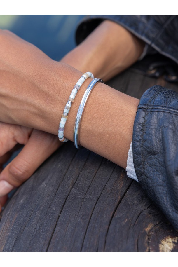 마야 루 팔찌 - 아크틱블루X실버는 여성용 팔찌로, 미니멀하고 캐주얼한 스타일을 연출합니다. 아크틱블루 컬러의 로프와 실버 컬러의 스테인리스 스틸의 조화가 돋보이며, 커프 스타일 디자인으로 제작되었습니다. 316L 스테인리스 스틸과 마린급 로프를 사용하여 방수 및 내식성이 뛰어나며, 수작업 스티치와 보이지 않는 이음새 마감으로 고급스러움을 더했습니다. 팔찌에는 레이저 각인으로 포인트를 주어 독특한 디자인을 완성했습니다. 일상생활에서 착용하기 좋은 팔찌입니다.
