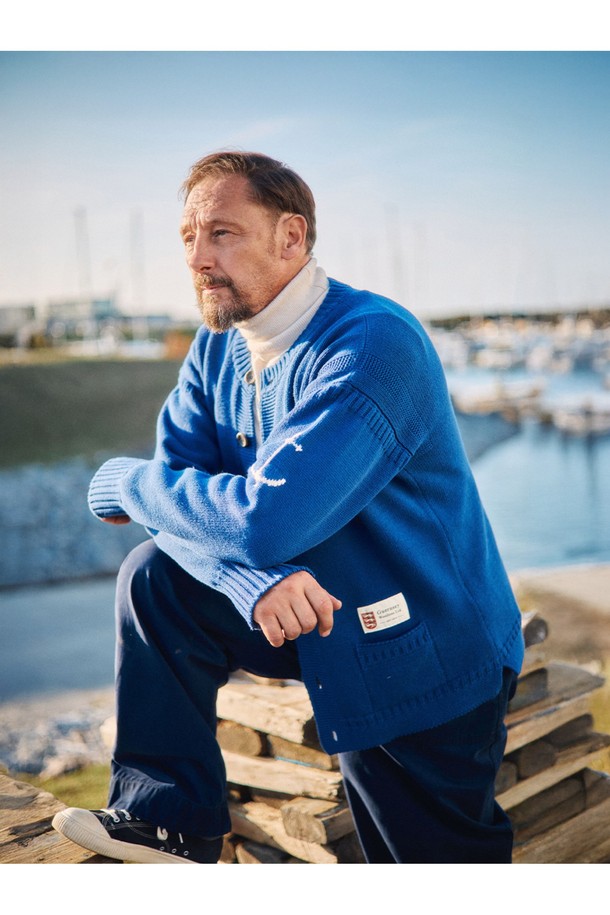 네이비 컬러의 헤비코튼 피셔맨 헤리티지 가디건입니다. 가을과 겨울, 일상 속에서 클래식하고 베이직한 스타일을 연출하기 좋습니다. 두꺼운 두께감의 면 소재로 제작되어 보온성을 높였으며, 단단한 촉감이 특징입니다. T자 형태의 헤리티지 패턴과 파도와 빗줄기를 형상화한 케이블 및 다이아몬드 무늬 짜임, 왼쪽 소매의 앵커 포인트가 돋보입니다. 핑거홀과 밑단 절개 디테일, 라운드넥, 레귤러핏, 긴소매, 버튼 여밈 방식으로 디자인되었습니다.
