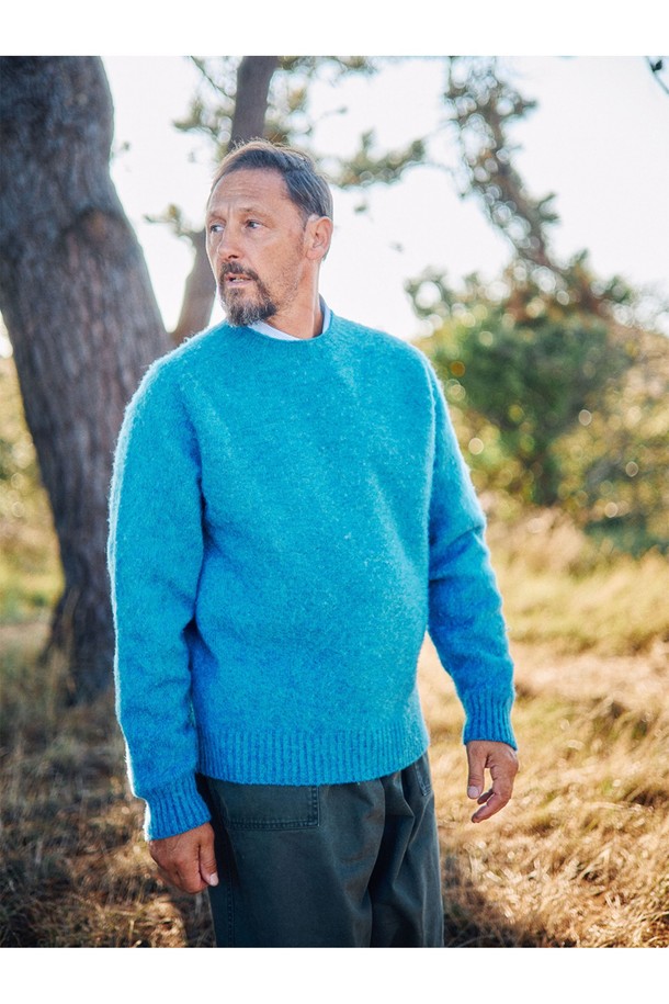 셔틀랜드울 쉐기독 홀가먼트 스웨터 - 피카딜리는 포근함과 클래식한 멋을 동시에 선사하는 남녀 공용 스웨터입니다. 셔틀랜드울 소재 특유의 부드러운 촉감과 두꺼운 두께감으로 가을, 겨울철 따뜻하게 착용 가능합니다. 브러싱 처리된 울 표면과 공기층 형성으로 보온성을 극대화했으며, 빈티지한 느낌을 더해주는 에이징 기법이 돋보입니다. 3차원 입체 실루엣과 왼쪽 소매 앵커 포인트 디테일, 전통적인 피셔맨 스웨터 디자인으로 미니멀, 클래식, 캐주얼 등 다양한 스타일을 연출할 수 있습니다. 다양한 색상 중 피카딜리 컬러는 어떤 룩에도 포인트를 더해줍니다.
