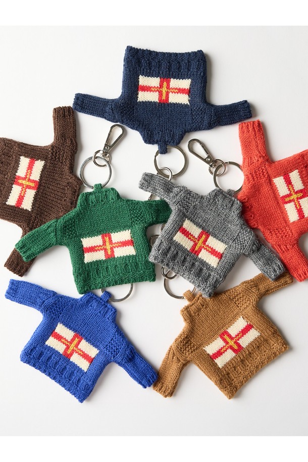 건지 더블크로스 스웨터 키링 - 오렌지는 클래식한 스타일의 키링입니다. 따뜻한 느낌을 주는 오렌지 컬러의 아크릴 소재로 제작되었으며, 두꺼운 두께감과 단단한 촉감이 특징입니다. 스웨터 모양 디자인에 더블크로스, 파도, 빗줄 패턴이 섬세하게 표현되어 있습니다. T자 형태 패턴과 밀도 높은 짜임, 여러 겹 꼬아 만든 원사가 돋보이는 디자인으로 보온 기능까지 갖춘 실용적인 아이템입니다. 흰 바탕에 붉은 세인트 조지 십자가와 금색 십자가가 포인트로 들어가 있습니다.
