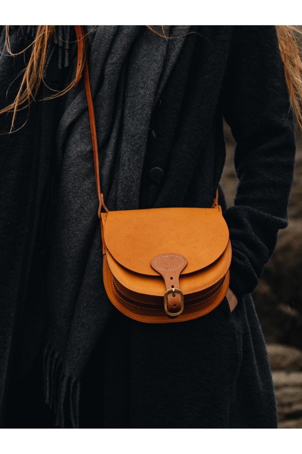 다이앤 새들백 M - 미엘은 클래식한 무드를 자아내는 남성용 새들백입니다. 블랙과 러스트 컬러로 출시되었으며, 식물성 태닝 처리된 풀그레인 소가죽 소재로 제작되어 자연스러운 가죽 질감을 느낄 수 있습니다. 내부에는 유기농 면을 사용하여 편안함을 더했으며, 황동 하드웨어와 YKK 지퍼, 수작업 마감으로 디테일을 높였습니다. 반원 형태의 디자인에 버클과 자수 장식이 포인트로, 출근룩, 비즈니스 캐주얼, 모임룩 등 다양한 TPO에 시크하고 미니멀한 스타일을 더해줍니다.
