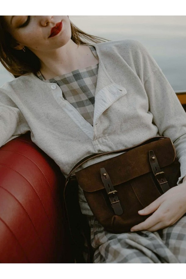 루이스 사첼백 - 쿠바 리브레는 베지터블 태닝 풀그레인 소가죽 소재의 미디엄 사이즈 여성용 사첼백입니다. "Cuba Libre"를 포함한 6가지 다채로운 컬러로 출시되었으며, 버클과 리벳 장식, YKK 지퍼, 황동 하드웨어로 고급스러움을 더했습니다. 7개의 지퍼 포켓, 2개의 폴딩 포켓, 4개의 패치 포켓을 갖춘 다중 수납공간과 모듈러 시스템 호환 기능을 통해 실용성을 높였으며, 버클형 및 버튼형 잠금 방식으로 내용물을 안전하게 보호합니다.
