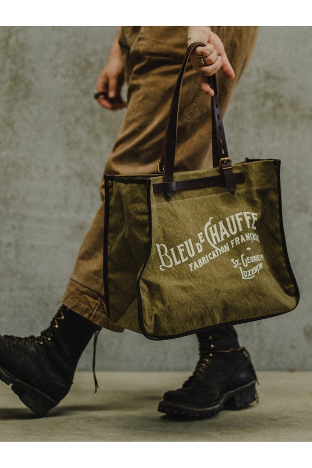 **바자 토트백 - 카키**

남성용 라지 사이즈 토트백으로, 캔버스, 소가죽, 면 소재를 사용하여 튼튼하고 고급스러운 외관을 자랑합니다. 카키, 블랙, 네이비, 아몬드 4가지 색상으로 출시되었으며, 가죽 디테일과 브라스 하드웨어 장식이 돋보입니다. 17인치 노트북 수납이 가능하며 방수 기능과 다양한 수납공간, 탈부착 가능한 내부 포켓을 갖춰 일상, 비즈니스, 여행 등 다용도로 활용할 수 있습니다.
