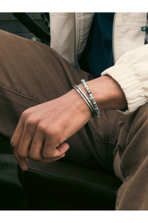 브론타이드(Brontide) 6 팔찌 - 하코다테X실버는 캐주얼, 미니멀, 클래식 스타일을 추구하는 남녀 모두를 위한 팔찌입니다. 해수 및 염분에 강한 316L 스테인리스스틸 소재와 고강도 마린로프를 사용하여 일상, 휴가, 여행 등 다양한 TPO에 착용하기 좋습니다. 6mm 두께의 브레이드(Braid) 패턴에 하코다테 컬러와 실버 컬러가 조화롭게 어우러지며, 레이저 각인과 매듭 디테일이 디자인의 완성도를 높입니다. 방수 및 내식 기능을 갖춰 땀에 변색될 걱정 없이 오랫동안 사용할 수 있으며, S, M, L 세 가지 사이즈로 출시됩니다. 프리미엄 우드 케이스에 담겨 제공되어 소중한 사람에게 선물하기에도 좋습니다.
