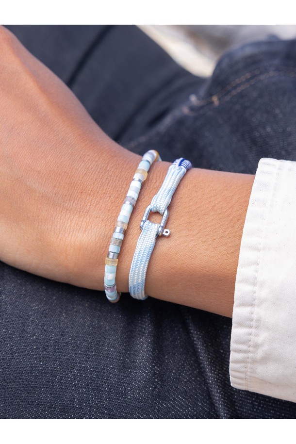 (여성) 프랭키 팔찌 - 아크틱블루, 크림, 실버는 미니멀, 클래식, 리조트 스타일을 즐기는 여성들을 위한 팔찌입니다. 아크틱블루, 크림, 실버 세 가지 색상의 조화가 돋보이며, 일상 및 파티룩에 모두 잘 어울립니다. 스테인리스 스틸과 로프 소재로 제작되어 내식성과 내구성이 뛰어나며, 100% 수작업으로 섬세하게 완성되었습니다. 선박용 플랫 로프를 사용하여 해수 및 염분에 강하며, 2개 이상 레이어드하여 착용하면 더욱 멋스러운 연출이 가능합니다. 레이저 각인과 매듭 디테일이 더해져 디자인의 완성도를 높였습니다.
