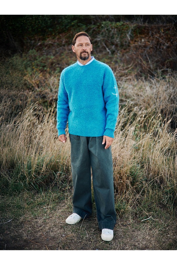 셔틀랜드울 쉐기독 홀가먼트 스웨터 - 피카딜리는 포근함과 클래식한 멋을 동시에 선사하는 남녀 공용 스웨터입니다. 셔틀랜드울 소재 특유의 부드러운 촉감과 두꺼운 두께감으로 가을, 겨울철 따뜻하게 착용 가능합니다. 브러싱 처리된 울 표면과 공기층 형성으로 보온성을 극대화했으며, 빈티지한 느낌을 더해주는 에이징 기법이 돋보입니다. 3차원 입체 실루엣과 왼쪽 소매 앵커 포인트 디테일, 전통적인 피셔맨 스웨터 디자인으로 미니멀, 클래식, 캐주얼 등 다양한 스타일을 연출할 수 있습니다. 다양한 색상 중 피카딜리 컬러는 어떤 룩에도 포인트를 더해줍니다.
