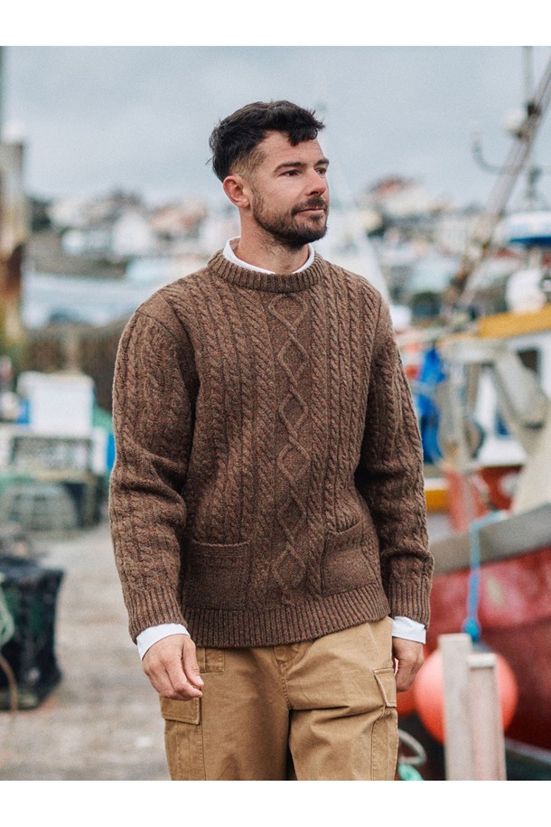 셔틀랜드울 아란 포켓 스웨터 - 모스 브라운은 클래식과 베이직 스타일을 추구하는 남성을 위한 겨울, 가을용 상의입니다. 두꺼운 두께감과 뻣뻣한 촉감, 보온 및 방풍 기능을 갖춘 이 스웨터는 일상과 출근룩, 모임룩에 적합합니다. 17세기 전통 편직 기법을 보존하여 제작되었으며, 전통적인 아란 니트 패턴과 포켓 디테일이 특징입니다. 링킹 기법으로 마감되었고, 아시아 체형에 맞는 사이즈로 제작되어 편안한 착용감을 선사합니다. 라운드넥, 긴소매, 레귤러핏의 레귤러 기장으로 디자인되었습니다.
