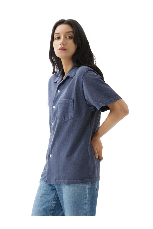 피그먼트 네이비 컬러의 오픈 카라 반팔 셔츠입니다. 부드러운 면 소재에 스탠다드 핏으로 제작되어 편안한 착용감을 선사하며, 일상복으로 활용하기 좋습니다. 2바늘 커버스티치 봉제와 목/어깨 보강 테이프로 내구성을 높였으며, 세탁과 착용을 통해 자연스러운 에이징 효과를 즐길 수 있습니다.
