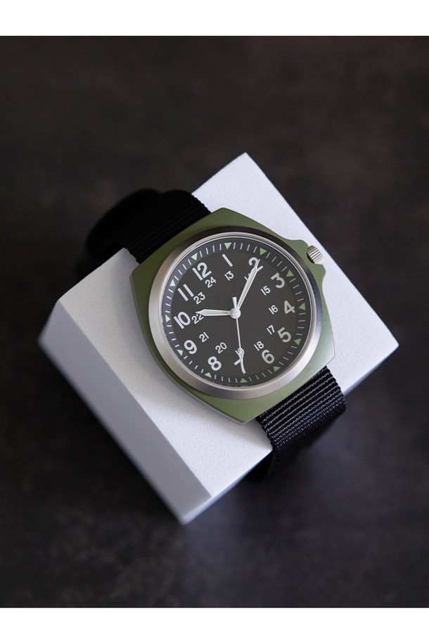 이라크전 시대를 재현한 올리브 색상과 블랙 색상의 밀리터리 필드 워치입니다. 남녀 모두 착용 가능하며, 38mm 케이스와 합금강 소재, 강화 미네랄 글라스를 사용했습니다. 미요타 2036 쿼츠 무브먼트, 슈퍼 루미노바 야광 기능, 3기압 방수를 지원하며 NATO 스트랩(18mm)을 사용했습니다.
