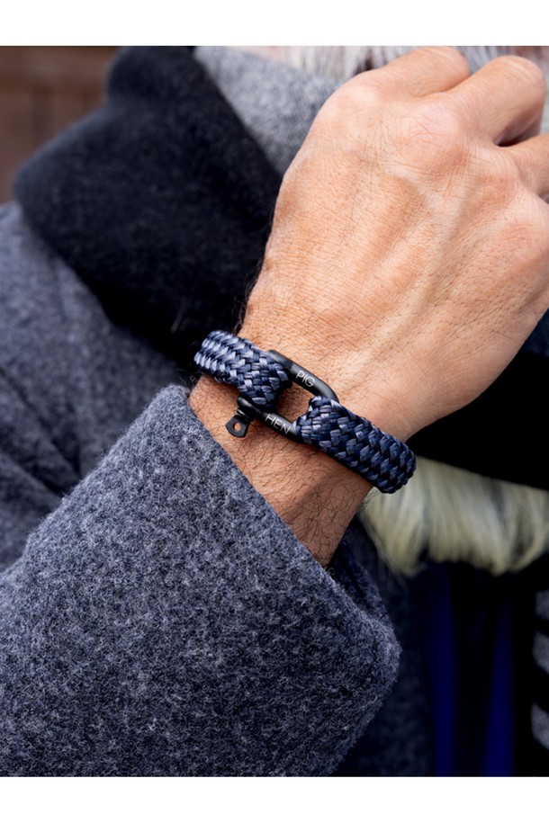 고저스 조지 팔찌는 네이비, 슬레이트그레이, 블랙 3가지 색상의 마린로프와 스테인리스 스틸 소재로 제작된 공용 팔찌입니다. 일상, 여행룩, 휴가룩 등 다양한 TPO에 활용 가능하며, 캐주얼, 미니멀, 클래식 스타일을 아우르는 디자인입니다. 팔찌에는 레이저 각인과 돼지, 닭 모티프 장식이 돋보이며, 수작업 스티치 및 매듭 마감으로 견고함을 더했습니다. 방수, 내구성, 내식성이 뛰어나며, 해수 저항성과 절단 저항성을 갖춰 오랫동안 변함없이 착용할 수 있습니다. 착용할수록 편안해지는 것이 특징이며, 녹슬지 않는 하드웨어와 우든 케이스 포장으로 고급스러움을 더했습니다.
