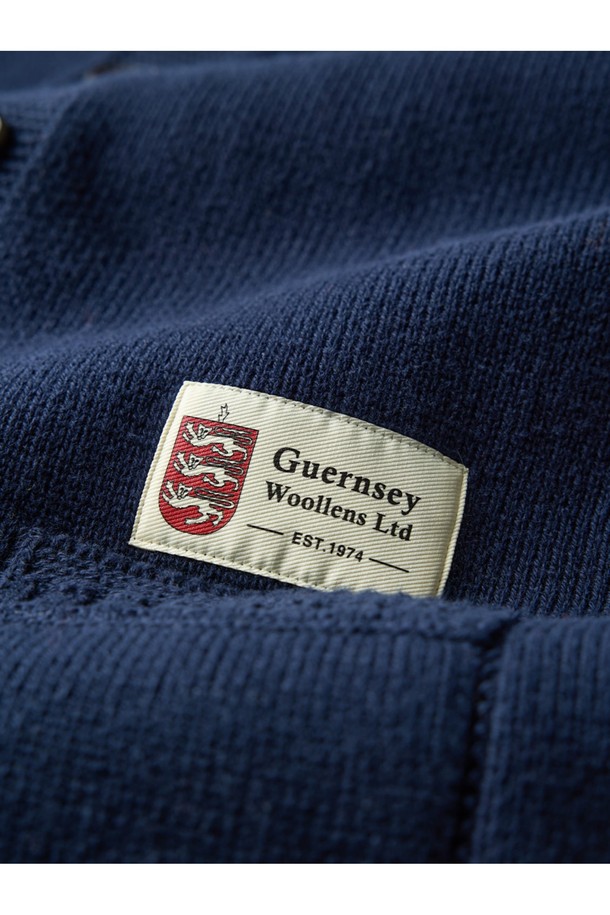 네이비 컬러의 헤비코튼 피셔맨 헤리티지 가디건입니다. 가을과 겨울, 일상 속에서 클래식하고 베이직한 스타일을 연출하기 좋습니다. 두꺼운 두께감의 면 소재로 제작되어 보온성을 높였으며, 단단한 촉감이 특징입니다. T자 형태의 헤리티지 패턴과 파도와 빗줄기를 형상화한 케이블 및 다이아몬드 무늬 짜임, 왼쪽 소매의 앵커 포인트가 돋보입니다. 핑거홀과 밑단 절개 디테일, 라운드넥, 레귤러핏, 긴소매, 버튼 여밈 방식으로 디자인되었습니다.
