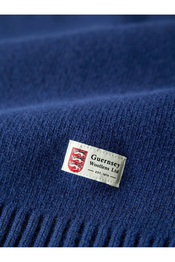 슈퍼 파인 메리노울 새들 스웨터 - 미드나잇 블루는 부드러운 촉감의 메리노울 소재로 제작된 레귤러핏 라운드넥 긴소매 스웨터입니다. 가을, 겨울 시즌에 어울리는 베이직하고 클래식한 스타일로, 일상복뿐만 아니라 출근룩으로도 활용 가능합니다. 얇은 두께감으로 편안한 착용감을 선사하며, 미니멀하고 캐주얼한 스타일을 연출하기 좋습니다. 특히, 영국 국기 패치 디테일이 포인트로 더해져 세련된 느낌을 줍니다.
