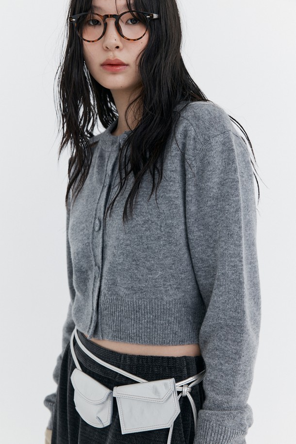 오픈 포인트 크롭 니트 가디건_그레이는 울 45%, 나일론 40%, 폴리에스터 15% 혼방 소재로 제작되어 부드러운 촉감과 뛰어난 보온성을 자랑합니다. 어깨 트임 디테일이 돋보이며, 허리 라인을 강조하는 크롭핏 디자인으로 세련된 실루엣을 연출합니다. 라운드넥에 긴소매, 무지 패턴으로 미니멀하고 클래식한 스타일을 완성하며, W-Logo 브로치(탈부착 가능)와 스페어 단추를 함께 제공합니다. 가을, 겨울 시즌 데이트룩, 카페룩, 데일리룩 등 다양한 TPO에 활용하기 좋으며, 시크하고 세련된 스타일을 연출할 수 있습니다.
