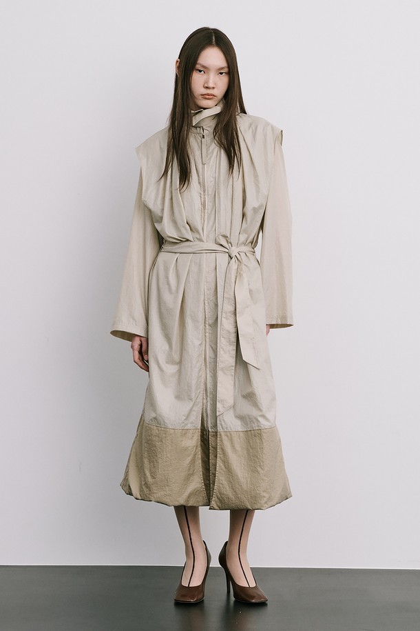 문(Moon) 자 모양의 베이지색 트렌치코트는 여성스러움을 강조한 미니멀하고 모던한 스타일의 아우터입니다. 얇은 나일론 소재로 제작되어 가볍고 산뜻한 착용감을 선사하며, 봄, 가을 간절기에 활용하기 좋습니다. 밑단이 어깨선까지 연결되는 독특한 디자인과 허리 벨트 구성으로 시크한 분위기를 연출하며, 롱 기장과 루즈핏으로 편안하게 착용할 수 있습니다. 출근룩, 오피스룩, 데이트룩 등 다양한 TPO에 활용하여 클래식하면서도 세련된 스타일을 완성해 보세요.

