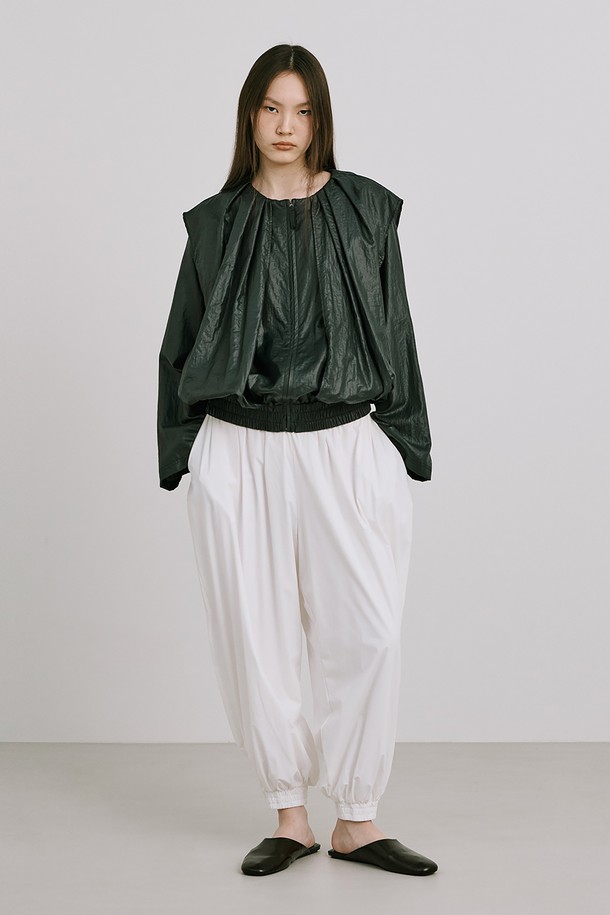 Shirred Moon Jar Pants_White는 부드러운 촉감과 얇은 두께로 편안한 착용감을 제공하는 여성용 슬랙스입니다. 루즈핏 디자인에 나일론, 스판덱스, 레이온 혼방 소재로 제작되었으며, 밑단 맞트임과 단추 디테일이 특징입니다. 봄, 여름 시즌에 어울리며, 미니멀, 모던, 캐주얼 스타일을 연출할 수 있는 무지 디자인의 긴바지입니다.
