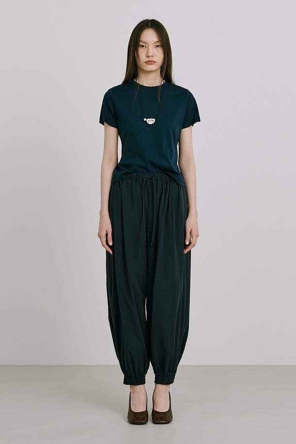 네이비 컬러의 Shirred Moon Jar Pants는 여성용 조거 팬츠로, 봄과 여름에 시원하게 착용하기 좋습니다. 부드러운 나일론, 스판덱스, 레이온 혼방 소재로 제작되어 루즈핏의 편안한 착용감을 선사하며, 움직임이 자유로운 디자인입니다. 밑단 맞트임과 단추 디테일로 포인트를 더했으며, 화이트 컬러는 안감이 내장되어 있습니다.
