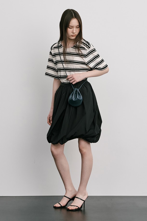 Moon Jar - Shaped Skirt_Black 스커트는 여성 의류로, 미니멀하고 모던한 스타일을 추구하는 분들을 위한 제품입니다. 봄, 여름에 어울리는 디자인으로, 블랙과 화이트 두 가지 색상으로 출시되었습니다. 잔터크와 셔링 디테일, 윤광이 흐르는 소재 표면, 벌룬 핏의 독특한 실루엣이 특징이며, 옆 혼솔지퍼로 편안하게 착용할 수 있습니다. 밑단에서 비틀어 허리에서 합봉하여 디자인의 완성도를 높였습니다.
